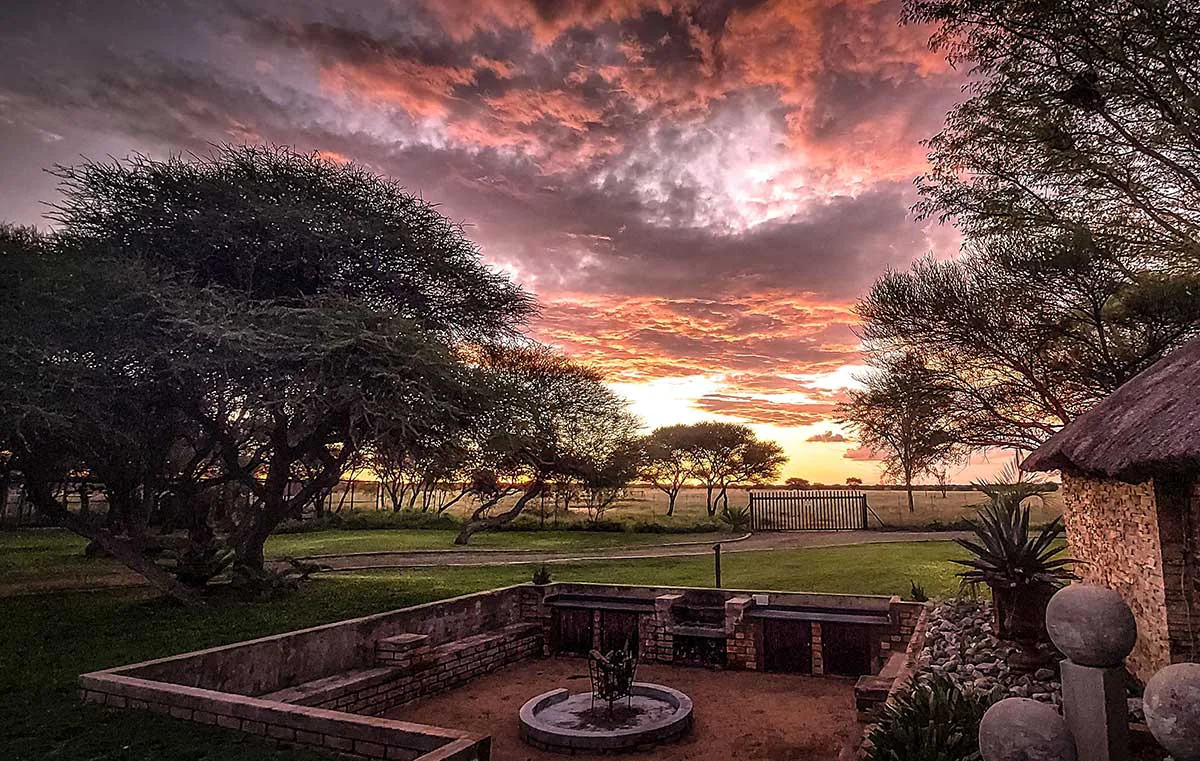 The brick boma and fire pit at Cruiser Safaris under a sunset sky