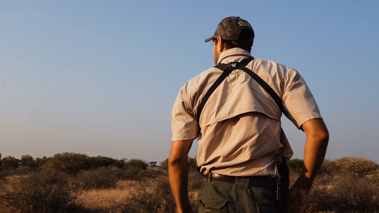 A professional hunter looking out over the bushveld at sunrise
