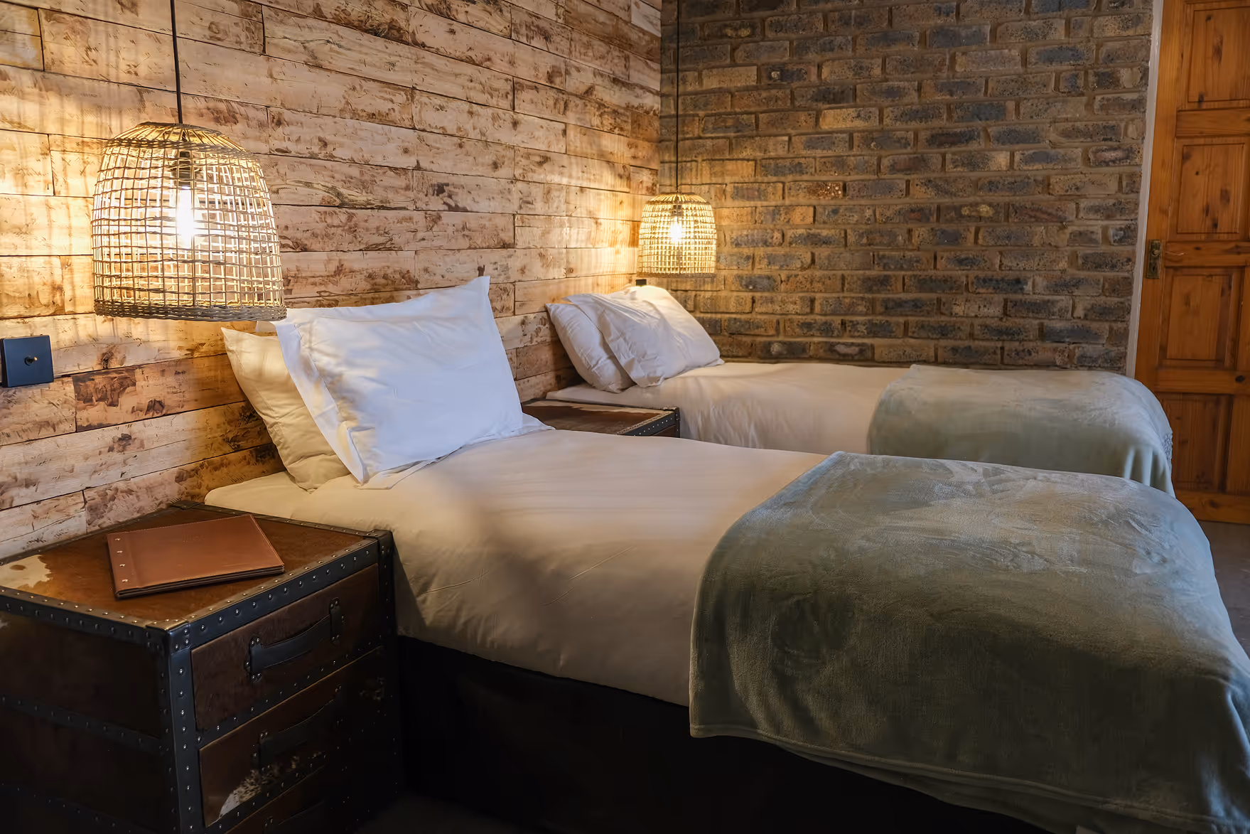Cozy bedroom with two single beds, white bedding and green blankets