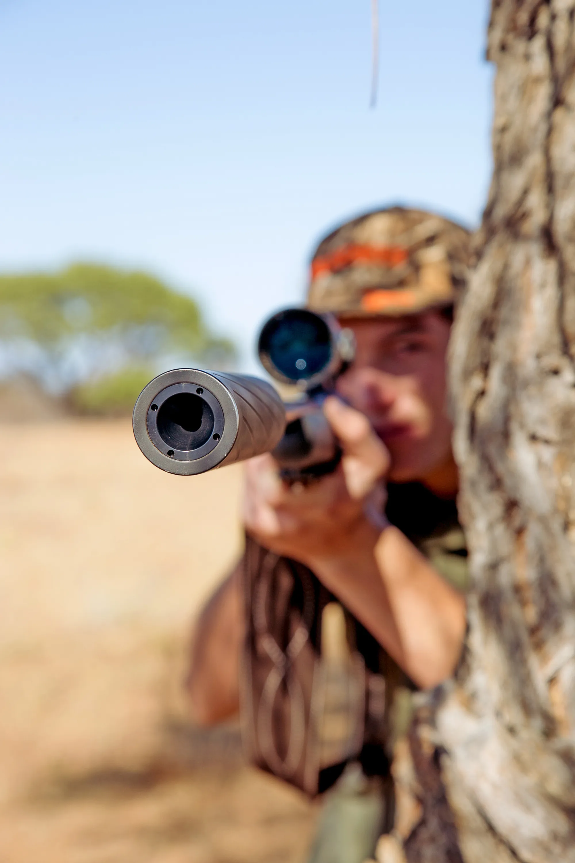 A professional hunter aiming a rifle